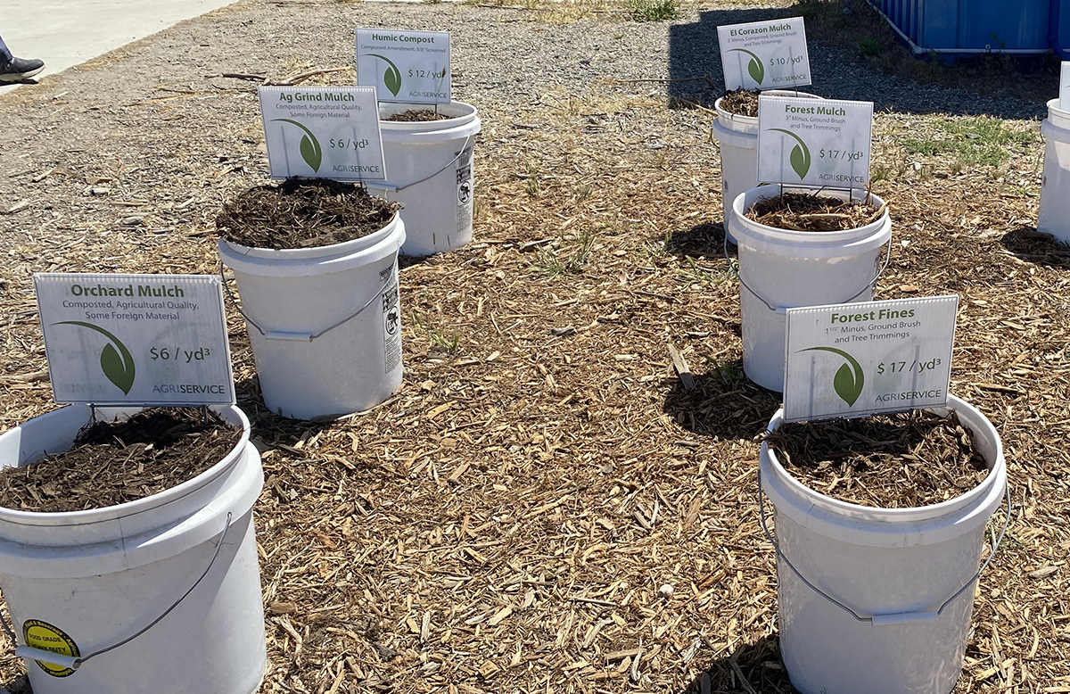 Buckets of different types of mulch for sale.