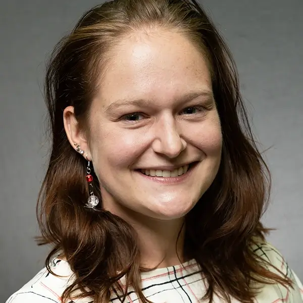 Smiling young white woman with brown hair and earrings