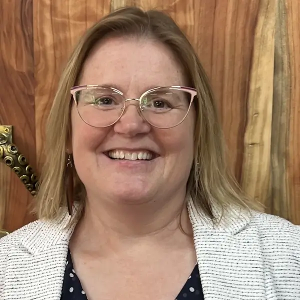 Caucasian woman wearing glasses and smiling